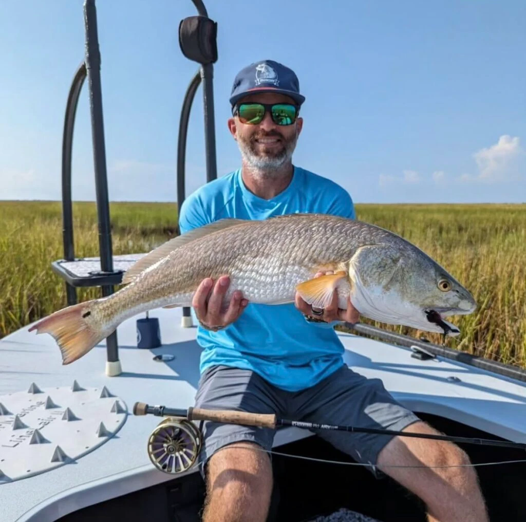 Man holding large fish on a boat during fishing trip
